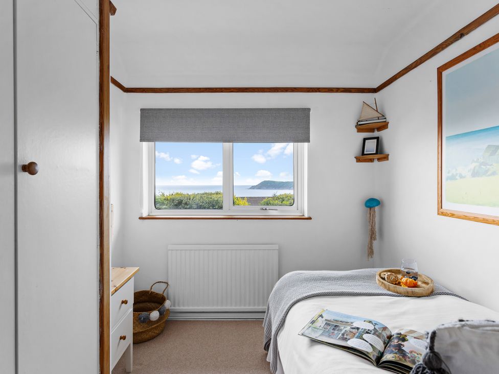 A bedroom with a window and a bed at 7 Duporth Bay in St. Austell