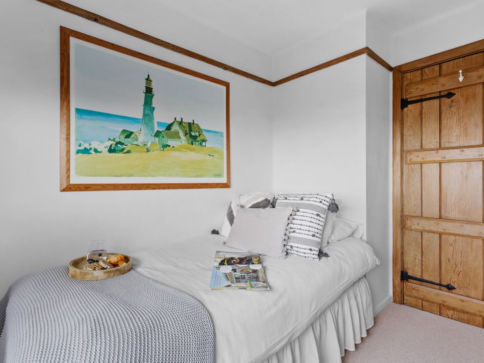 A bedroom with a bed and a picture on the wall at 7 Duporth Bay in St. Austell