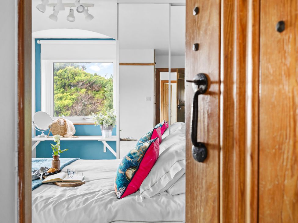 A bedroom with a bed and window at 7 Duporth Bay St. Austell