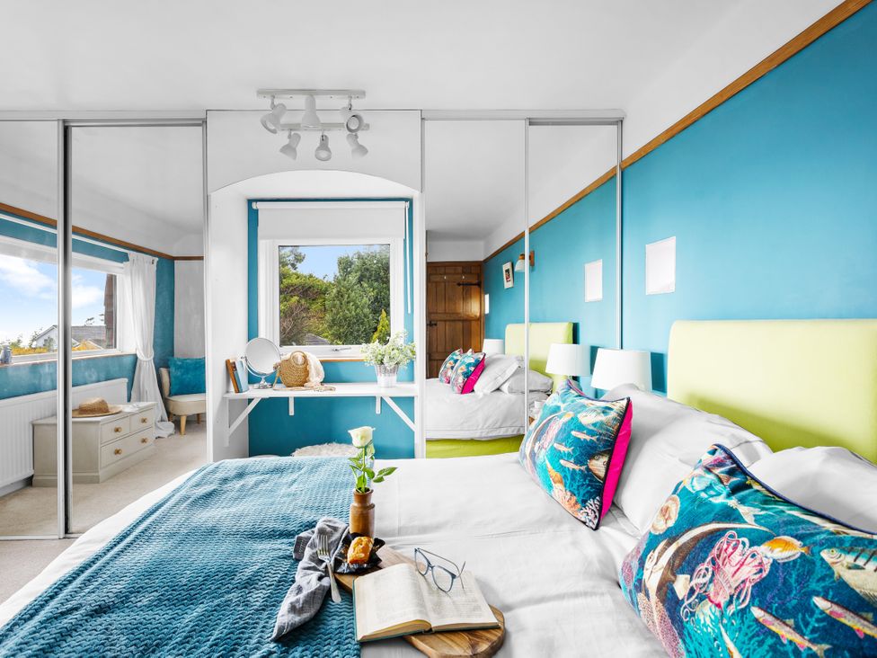 A bedroom with two beds and a window at 7 Duporth Bay in St. Austell