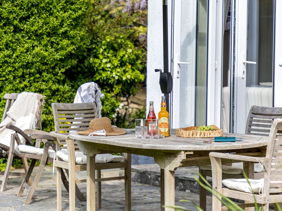 An outdoor patio with a table and chairs at 7 Duporth Bay in St. Austell
