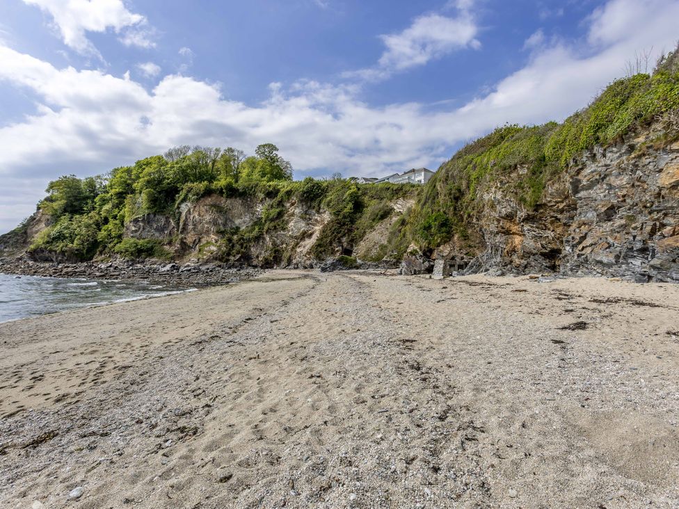 A beach with sand and cliffs at 7 Duporth Bay in St. Austell