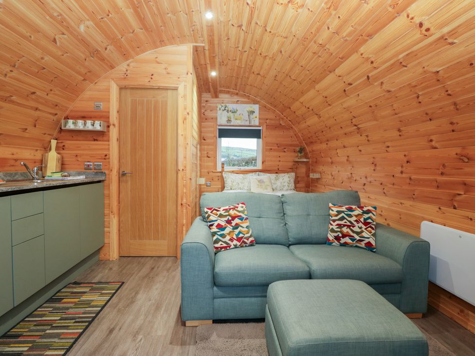 A living room with a sofa and kitchen cabinet at Beech in Ulverston
