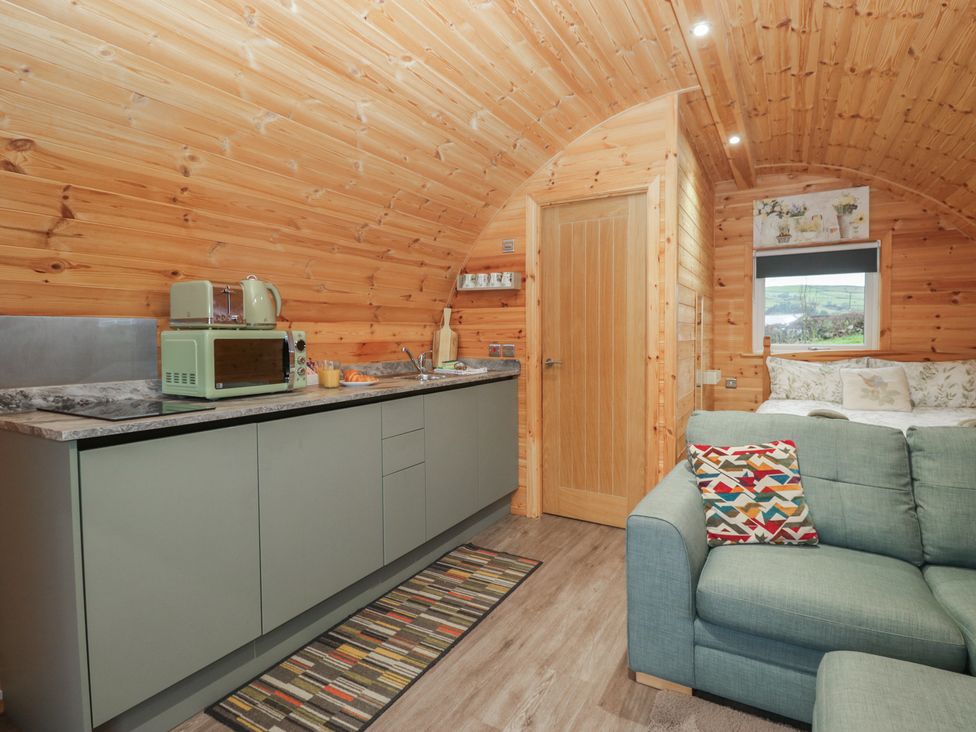 A kitchen with cabinetry and a sofa at Beech in Ulverston