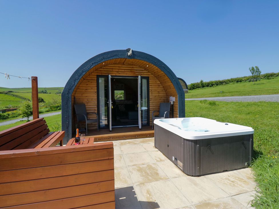 An outdoor area with a hot tub and wooden seating at Beech in Ulverston