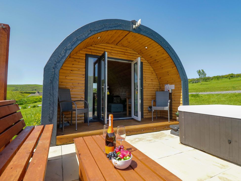 An outdoor area with a wooden pod structure and seating at Beech in Ulverston