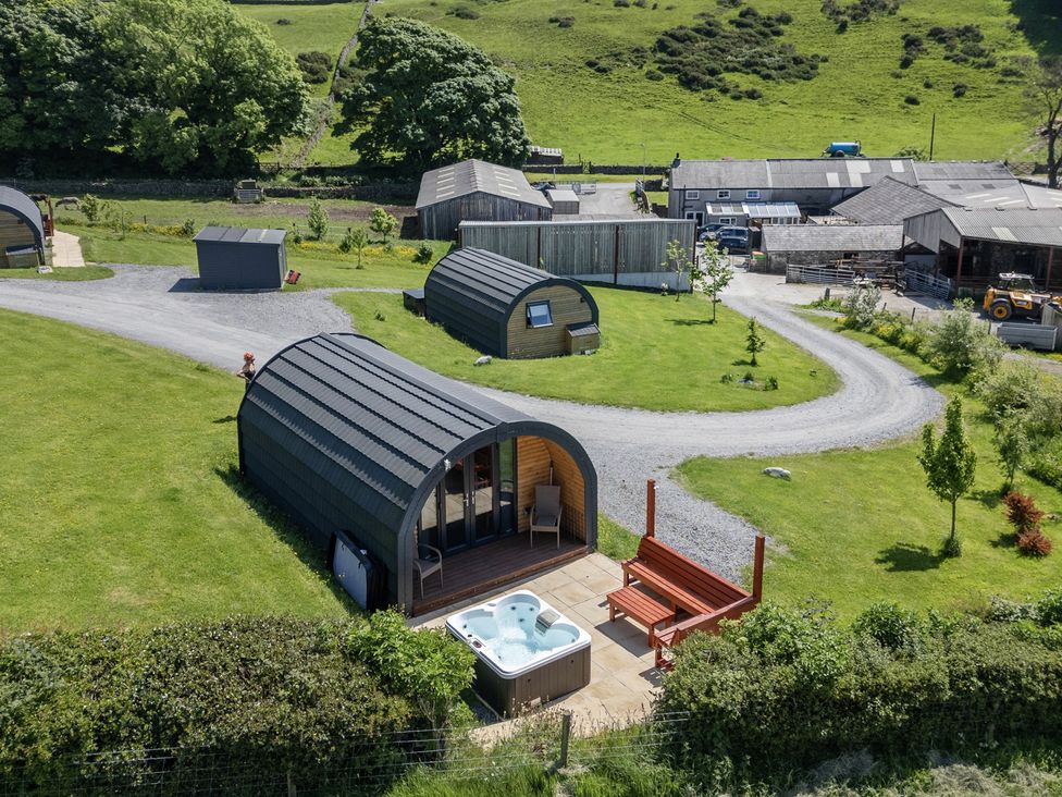An outdoor area with cabins and a hot tub at Beech in Ulverston