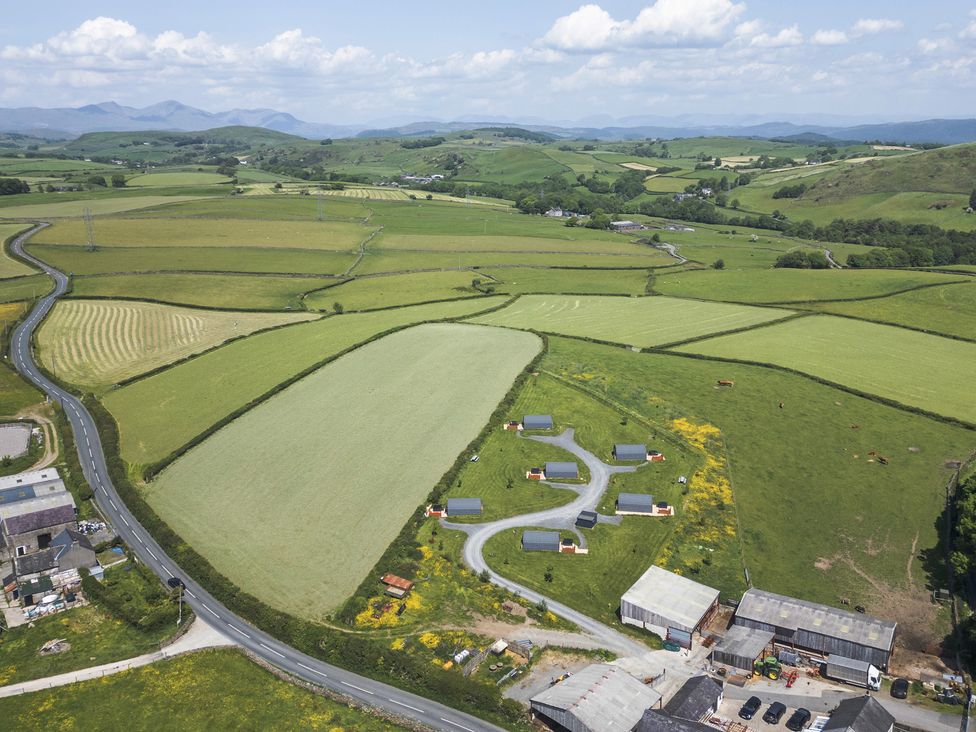 An aerial view of a rural area with fields and houses at Beech in Ulverston