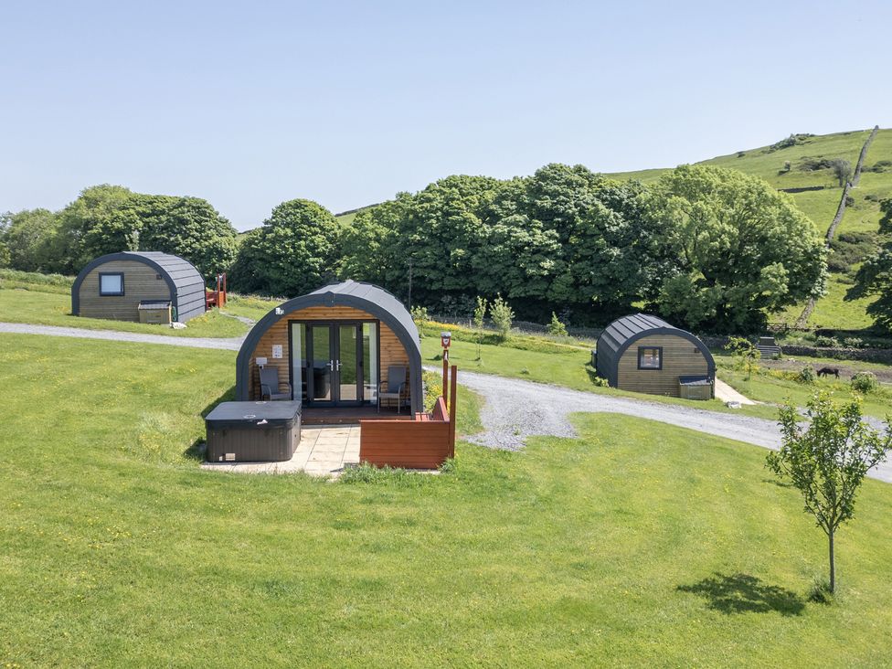 Glamping pods with a hot tub on a grassy area at Beech in Ulverston