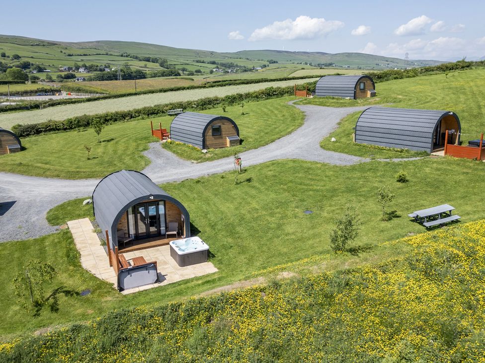 A glamping site with several pods and a hot tub at Beech in Ulverston