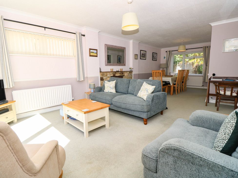A living room with sofas and a dining area at Altair in Colwell Bay near Freshwater