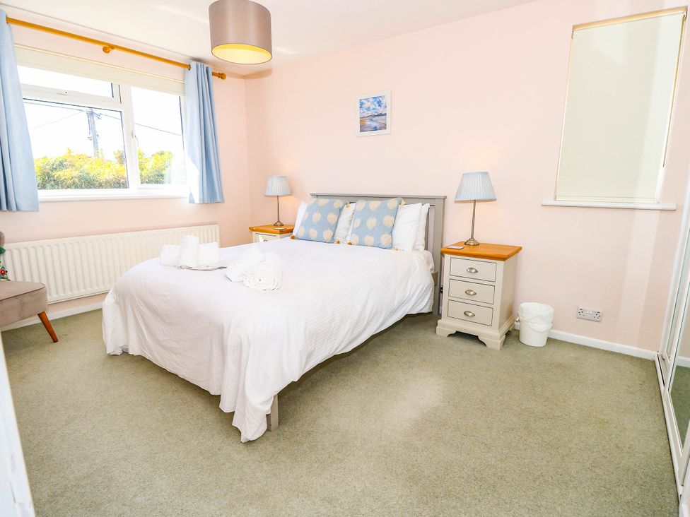 A bedroom with a bed and nightstand at Altair in Colwell Bay near Freshwater