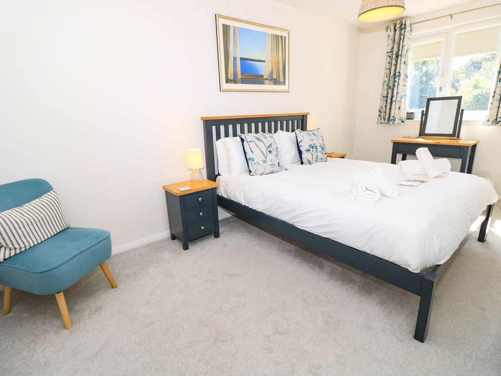 A bedroom with a bed and bedside table at Altair in Colwell Bay near Freshwater