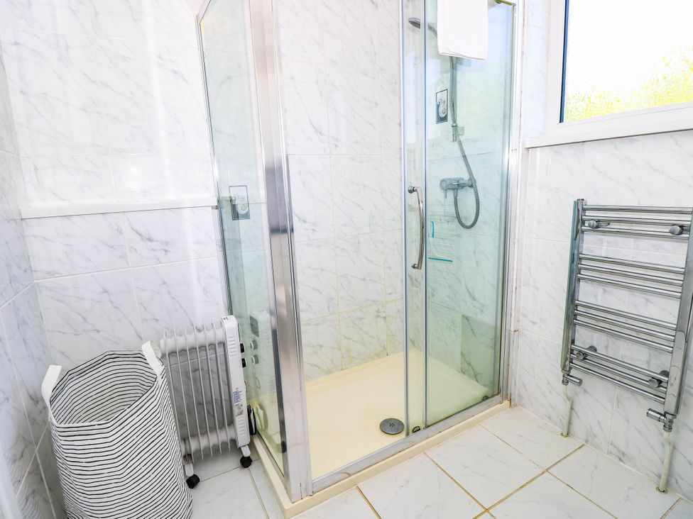 A bathroom featuring a shower and towel radiator at Altair in Colwell Bay near Freshwater