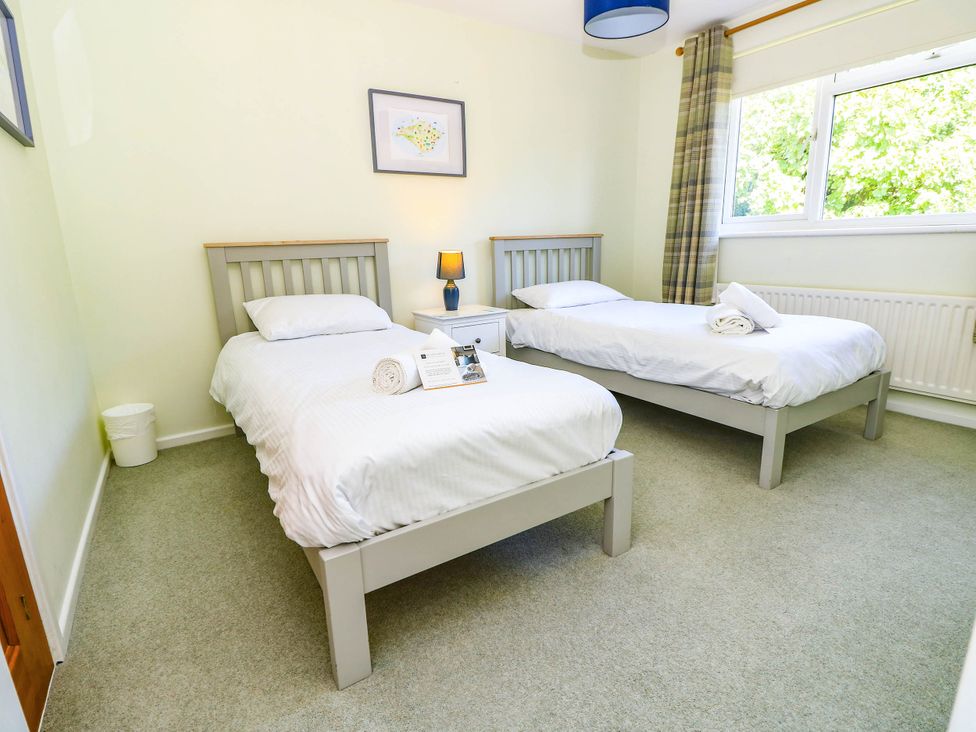 A bedroom with two single beds at Altair in Colwell Bay near Freshwater