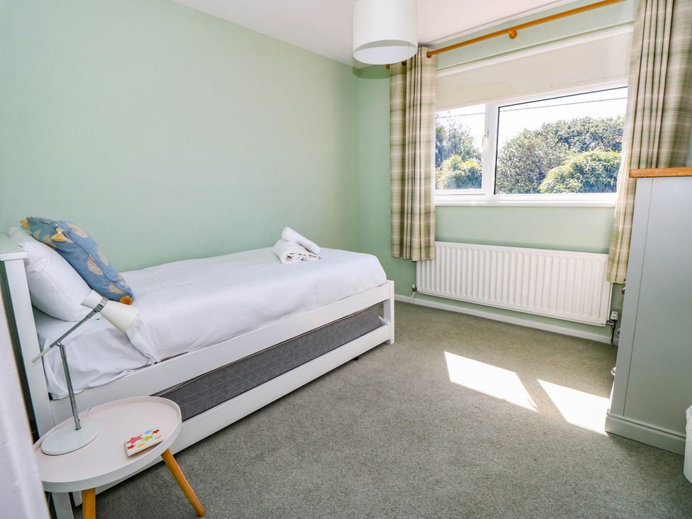 A bedroom with a single bed and a bedside lamp at Altair Colwell Bay near Freshwater