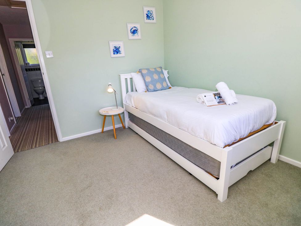 A bedroom with a single bed and bedside table at Altair in Colwell Bay near Freshwater