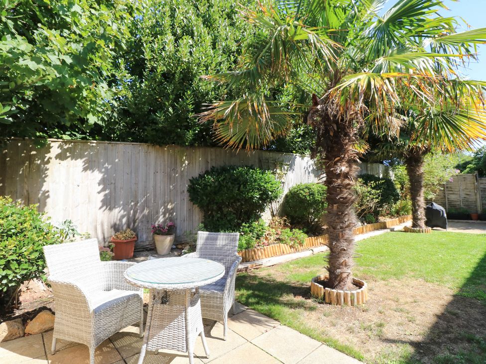 A garden with palm trees and furniture at Altair in Colwell Bay near Freshwater