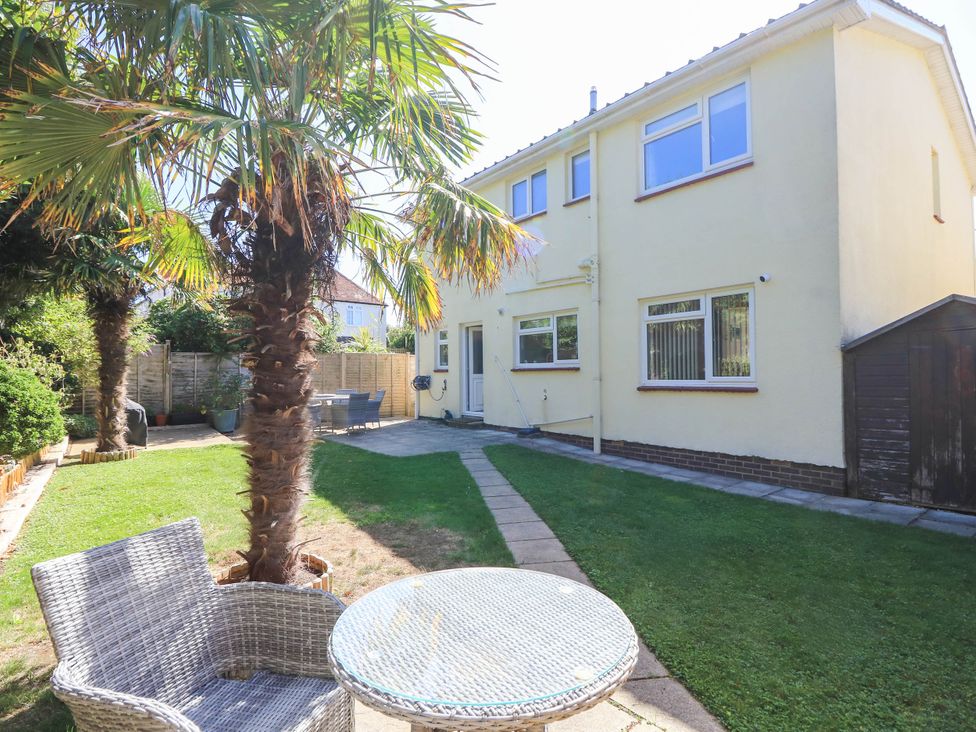 A garden with palm trees and a table at Altair in Colwell Bay near Freshwater