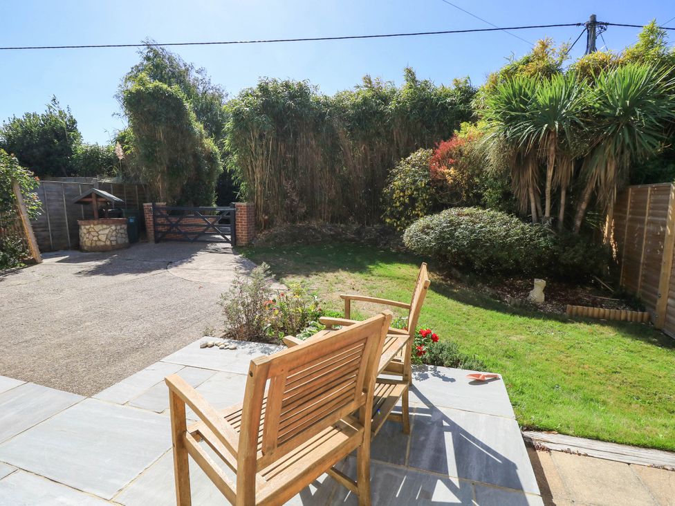 A garden area with wooden chairs and a gated entrance at Altair in Colwell Bay near Freshwater