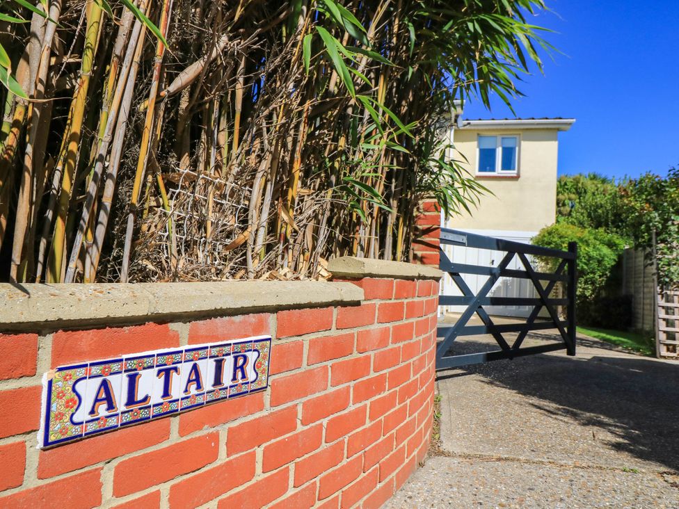 An outdoor area with bamboo, gate, and signage at Altair in Colwell Bay near Freshwater