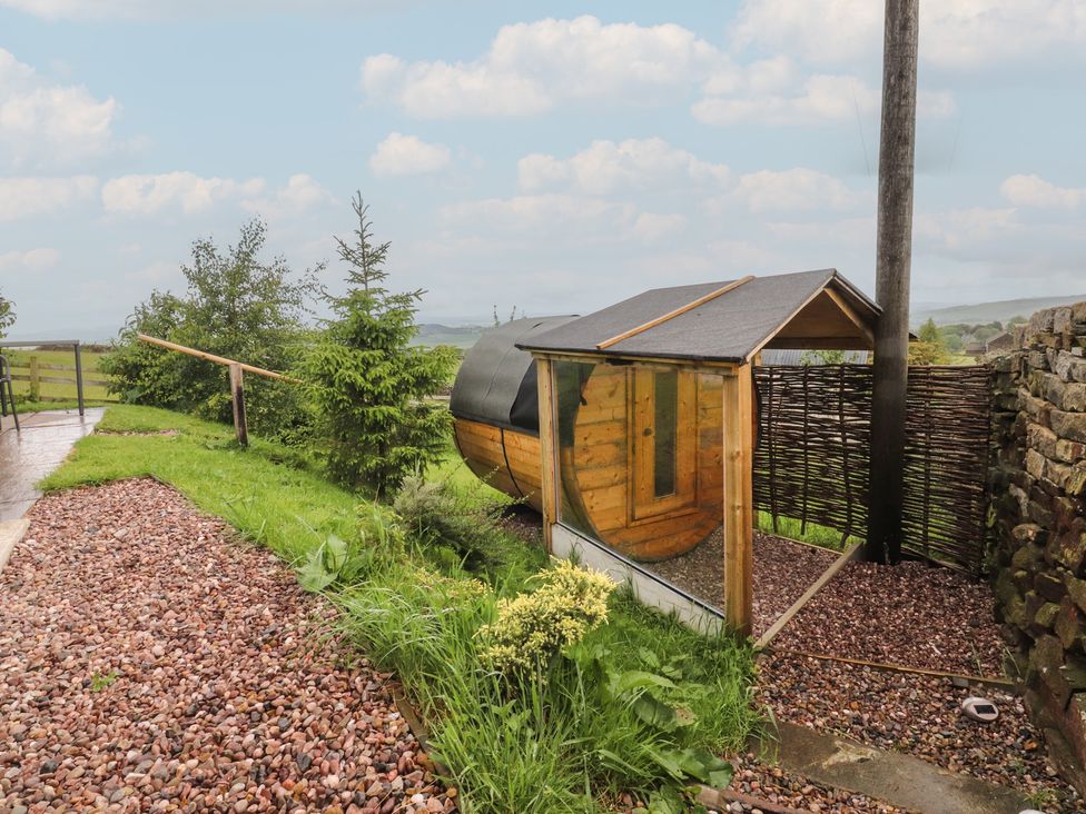A shepherd's hut in a garden at The Herdsman Luxury Shepherds Hut in Barnoldswick