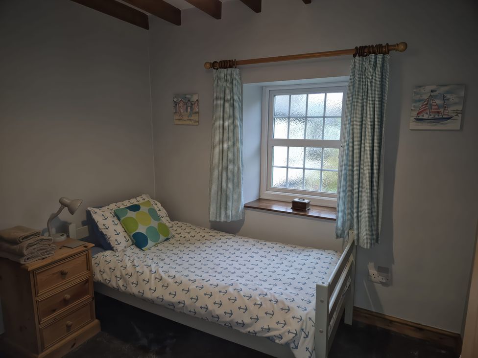 A bedroom with a bed and bedside table at Ty Gwenyn in Rhydwyn