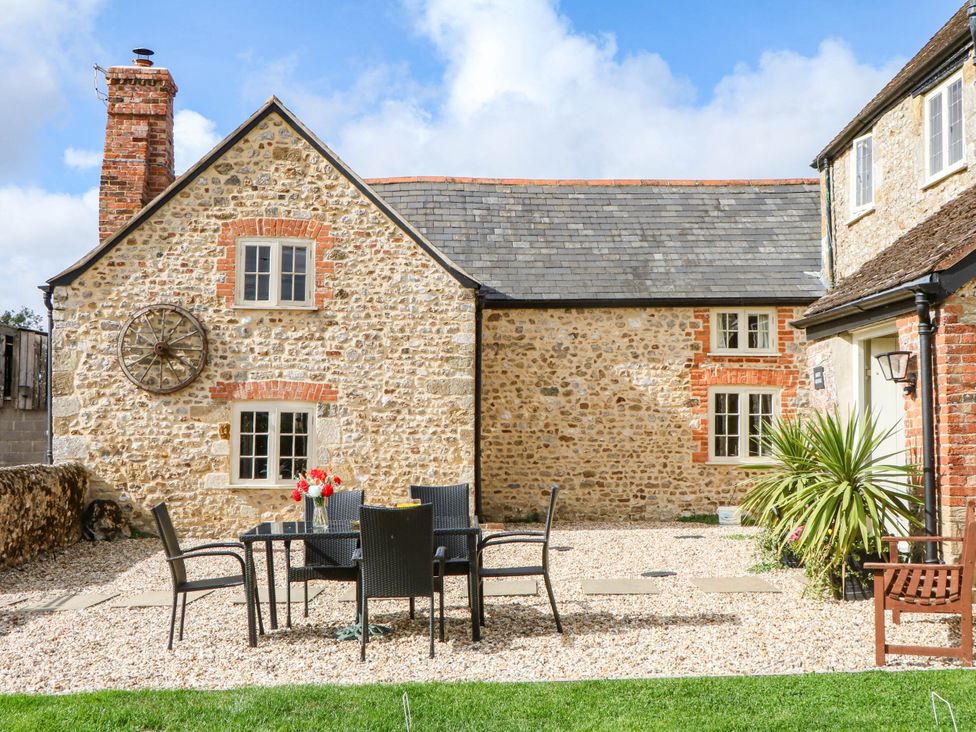 An outdoor dining area with a table and chairs at The Abbey Grange near Charmouth
