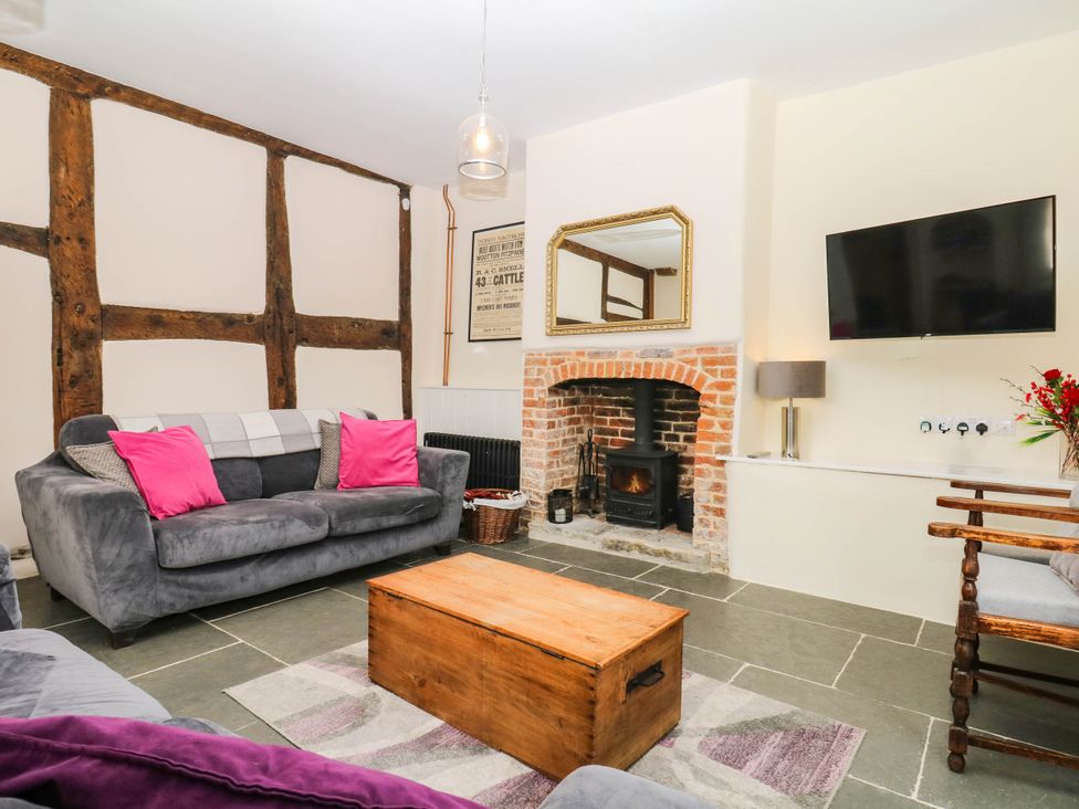 A living room with a fireplace and sofa at The Abbey Grange near Charmouth