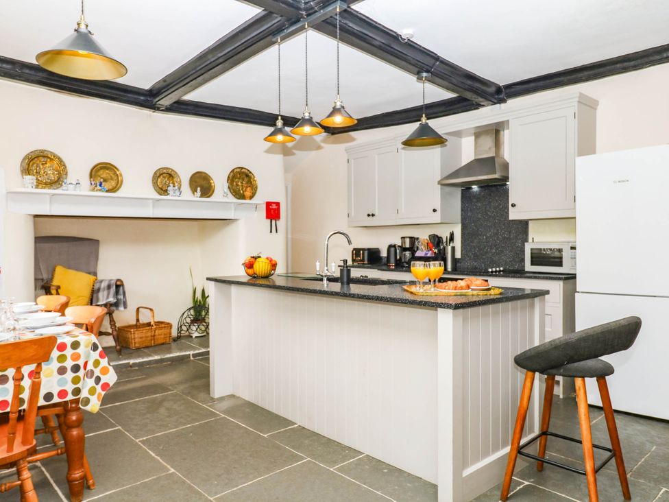 A kitchen with an island and stools at The Abbey Grange near Charmouth