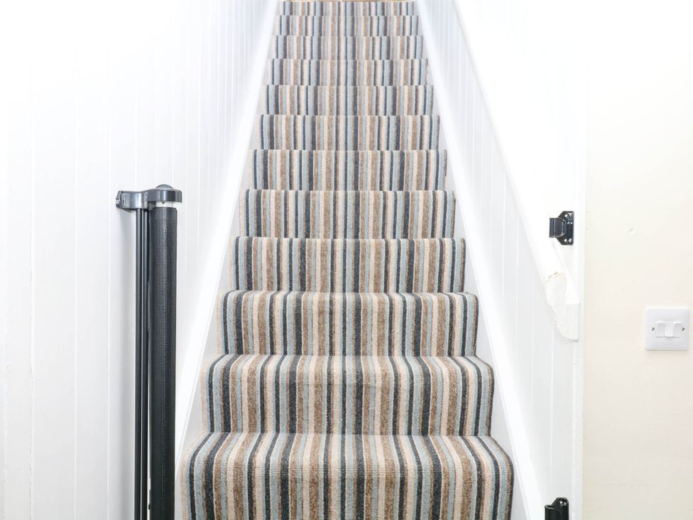 A staircase with striped carpet at The Abbey Grange near Charmouth