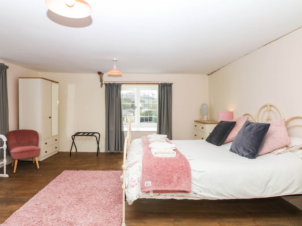 A bedroom with a bed and wardrobe at The Abbey Grange near Charmouth