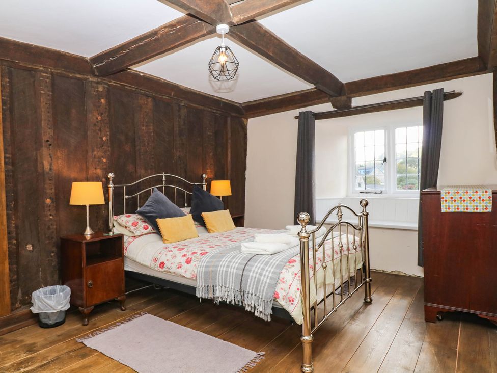 A bedroom with a bed and nightstand at The Abbey Grange near Charmouth