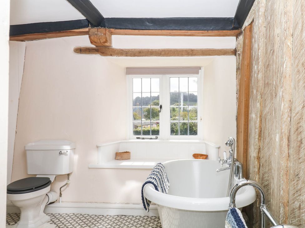 A bathroom with a bathtub and toilet at The Abbey Grange near Charmouth