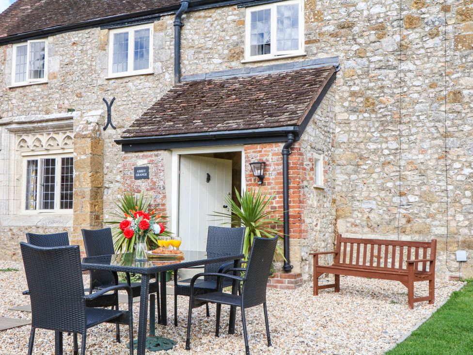 An outdoor dining area with a table and chairs at The Abbey Grange near Charmouth