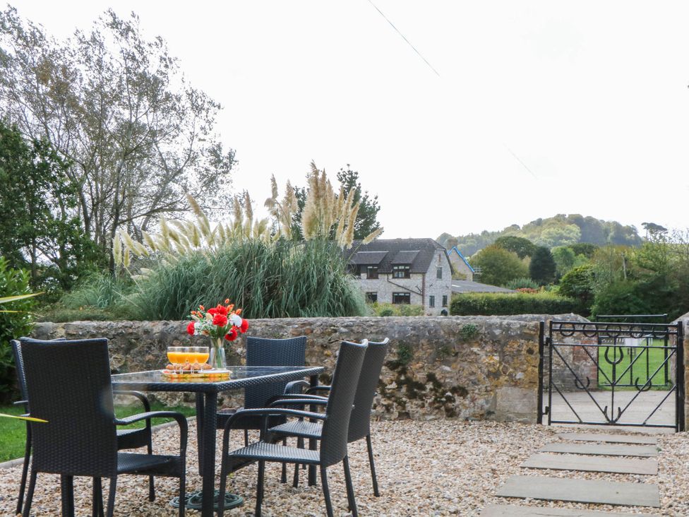 A table with drinks and chairs in a garden at The Abbey Grange near Charmouth