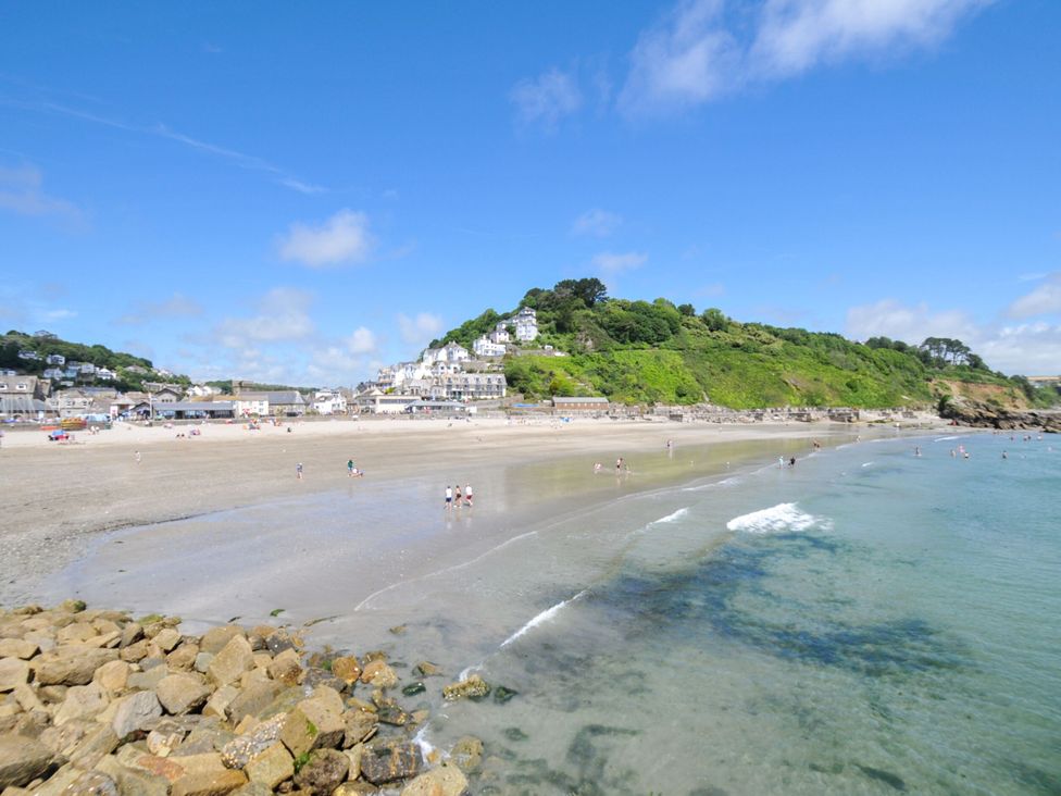 A beach with water and people near buildings at The Abbey Grange near Charmouth