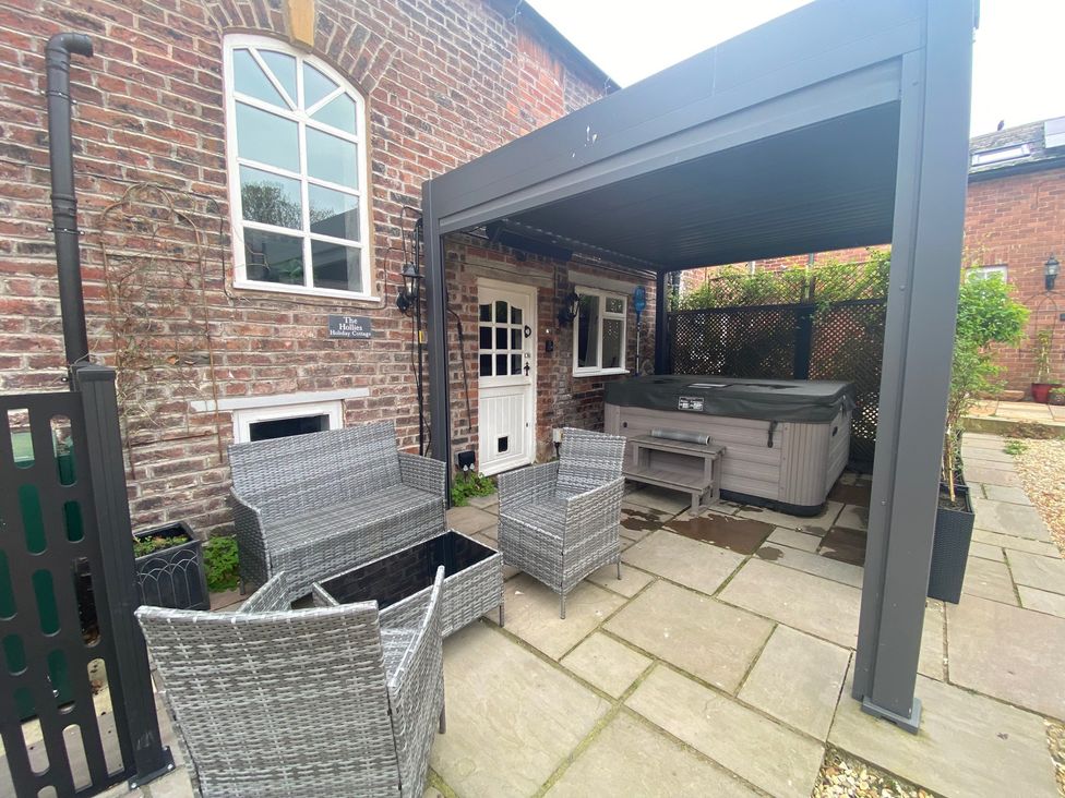 An outdoor area with seating and a hot tub at The Hollies in Thurstonfield near Carlisle