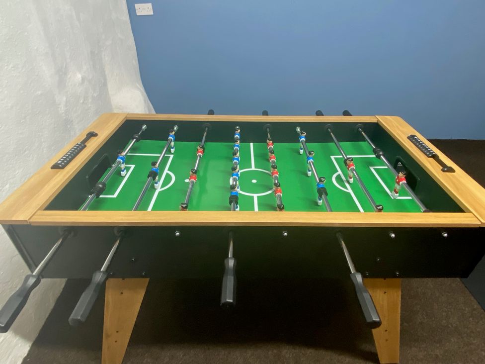 A foosball table with red and blue figurines in a game room at The Hollies in Thurstonfield near Carlisle