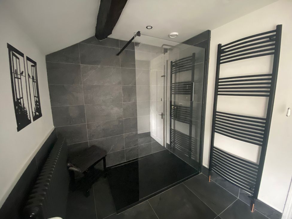 A bathroom with a shower and radiator at The Hollies in Thurstonfield near Carlisle