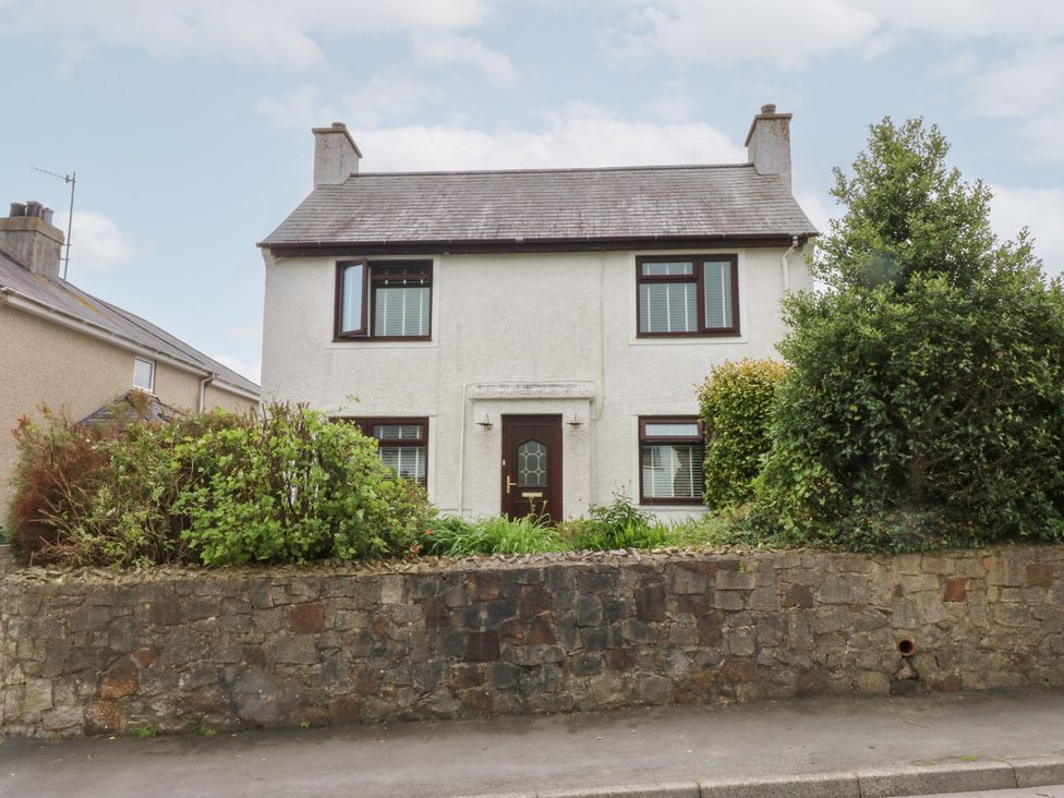 A house with a garden and stone wall at Fairfield in Llanbedrog