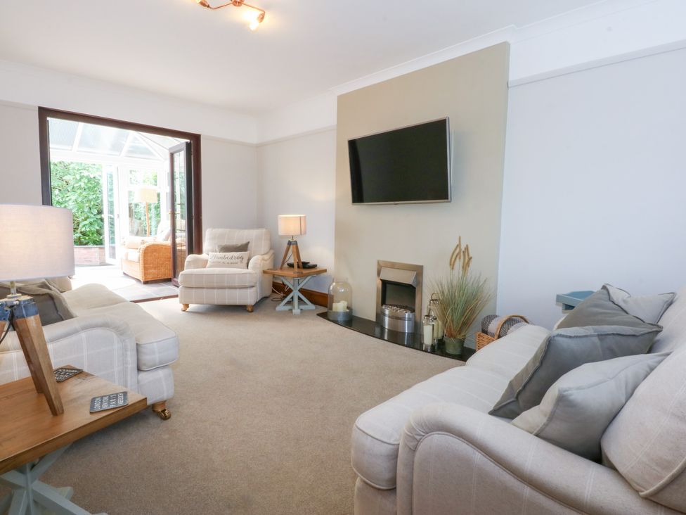 A living room with a sofa and armchair at Fairfield in Llanbedrog