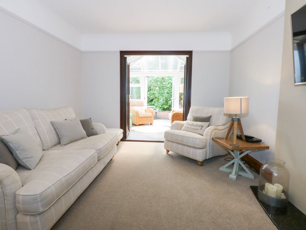 A living room with a sofa and armchair at Fairfield in Llanbedrog