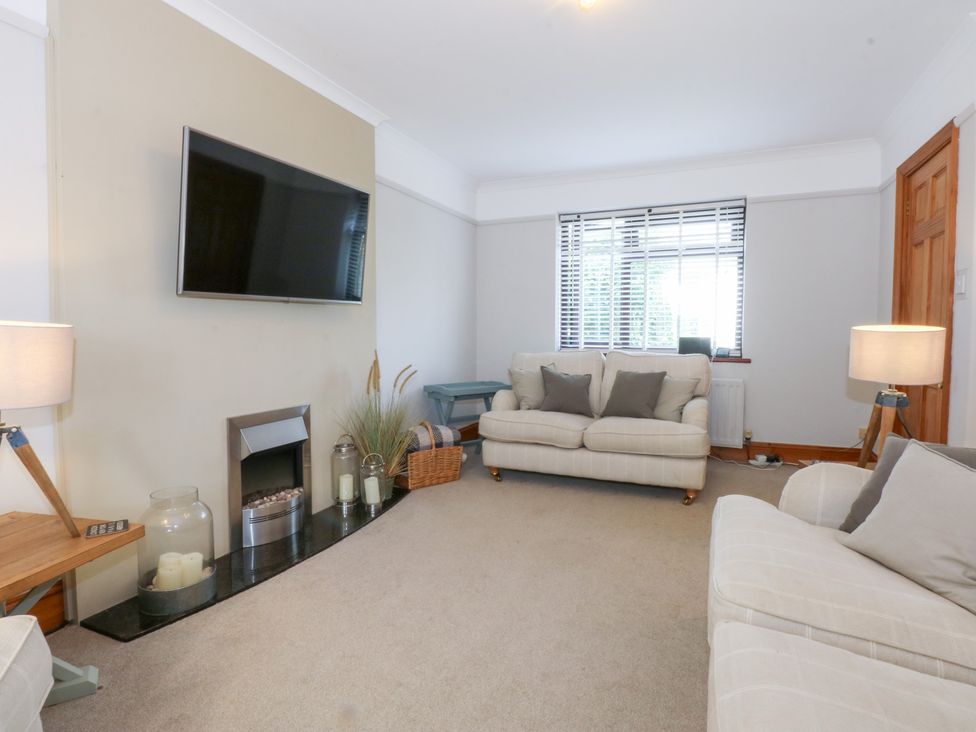 A living room with a television and a sofa at Fairfield in Llanbedrog