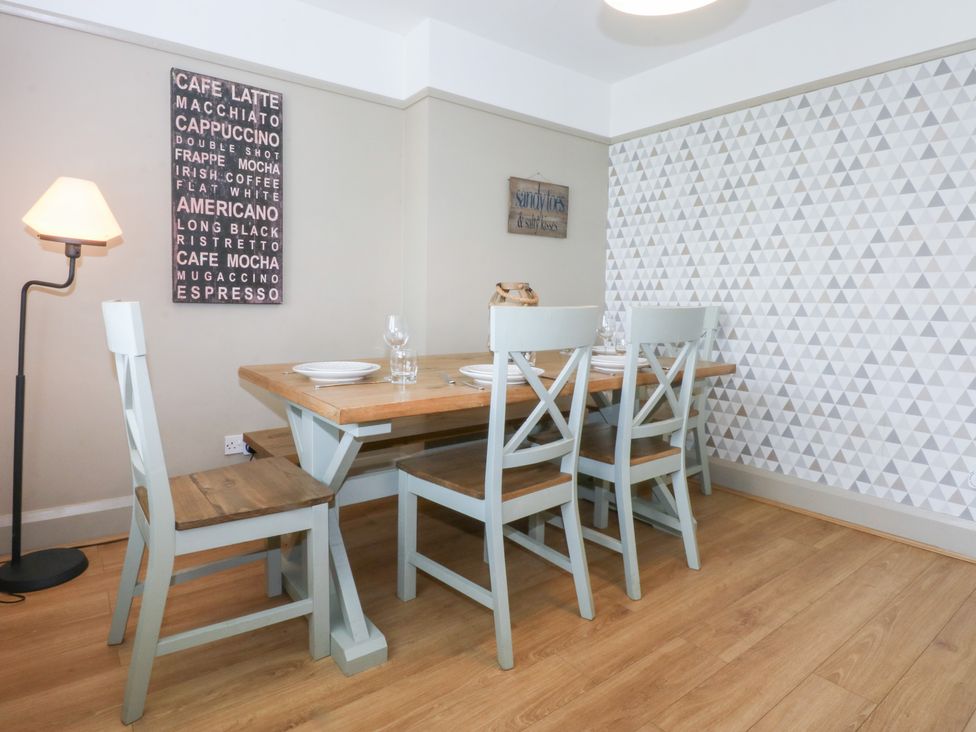A dining room with a wooden table and chairs at Fairfield in Llanbedrog