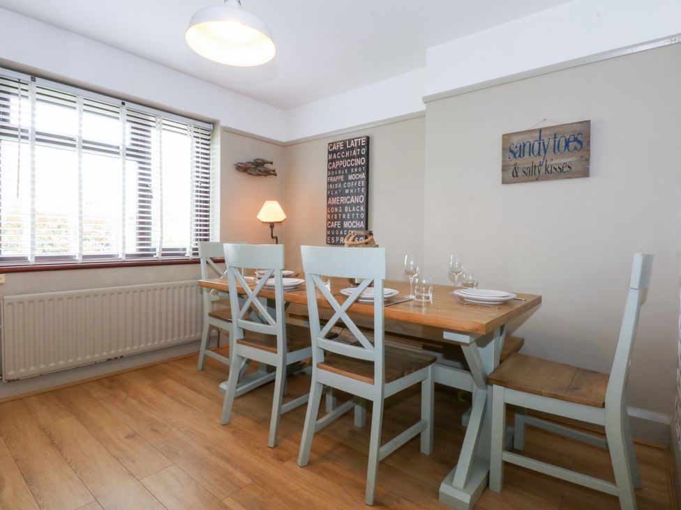 A dining room with a table and chairs at Fairfield in Llanbedrog