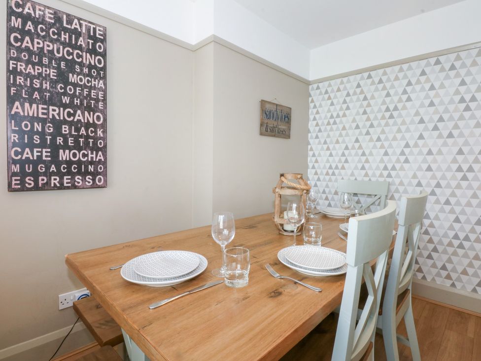 A dining area with a table and chairs at Fairfield in Llanbedrog