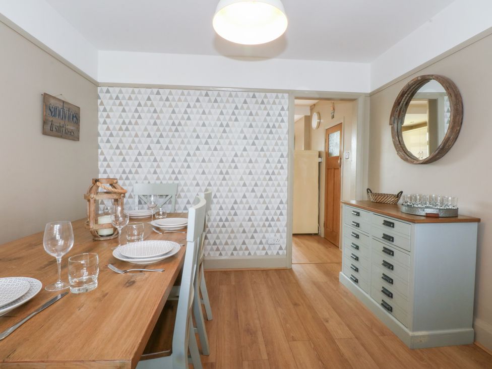 A dining room with a table and chairs at Fairfield in Llanbedrog