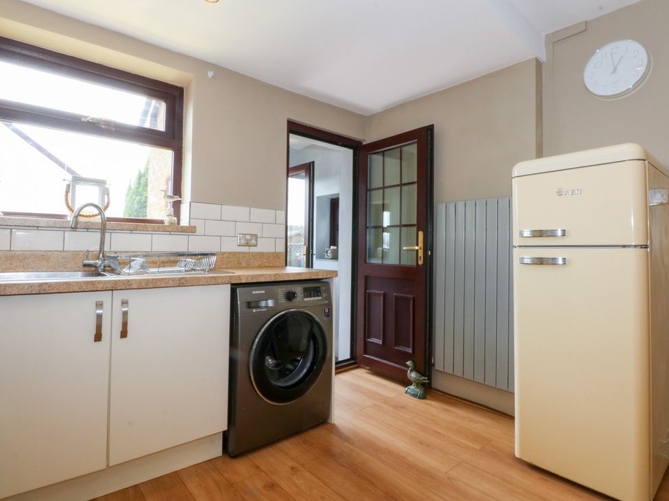 A kitchen with a washing machine and refrigerator at Fairfield in Llanbedrog