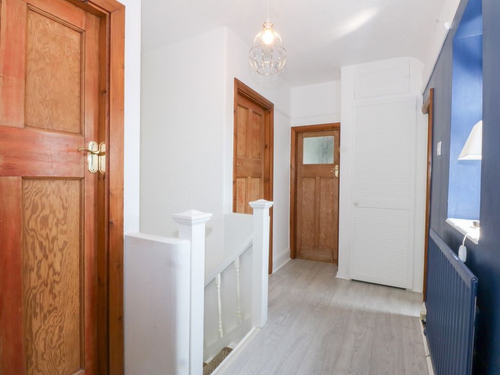 A hallway with doors and a staircase at Fairfield in Llanbedrog
